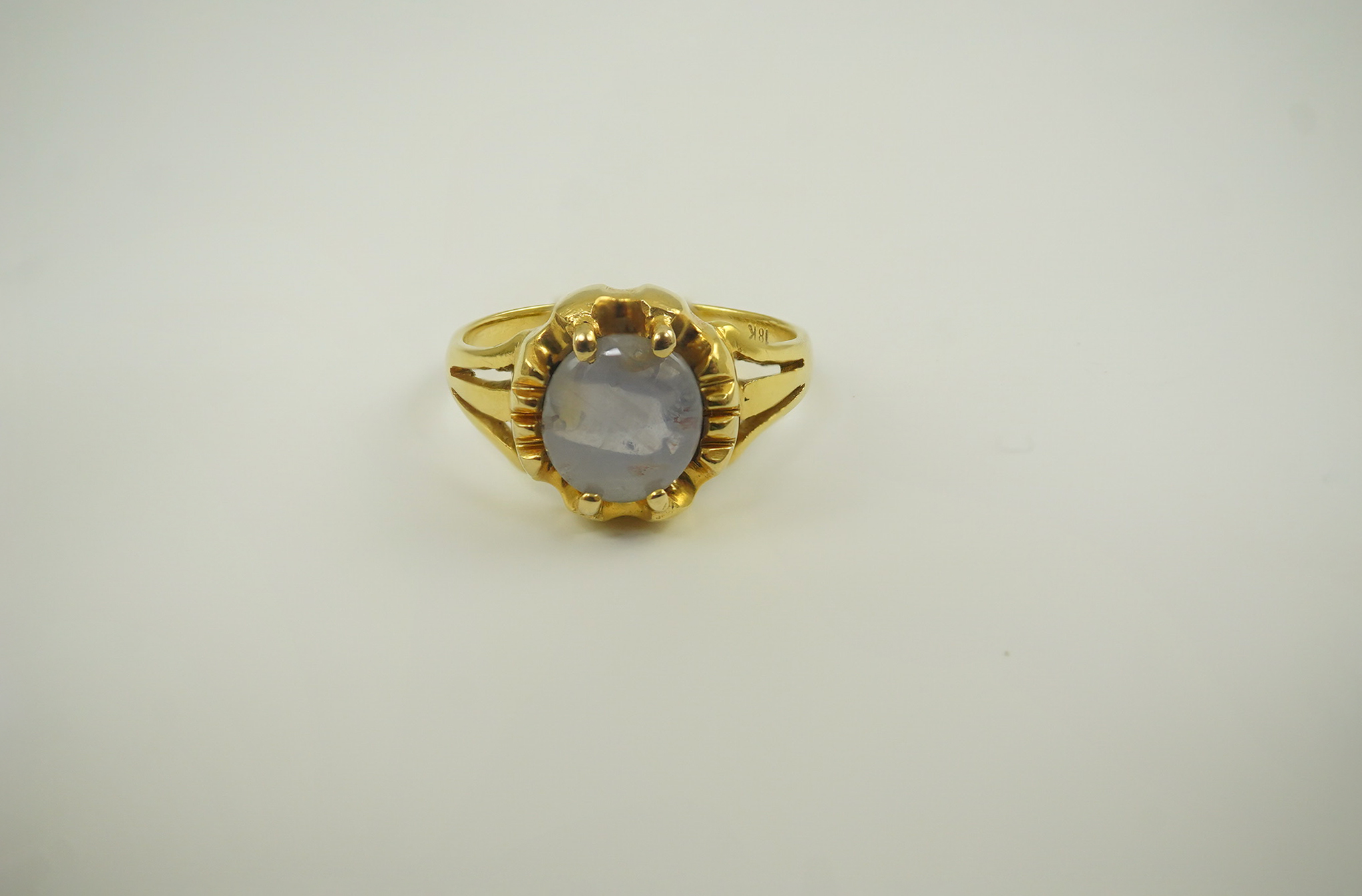 A modern 18k gold and single stone cabochon star sapphire set ring